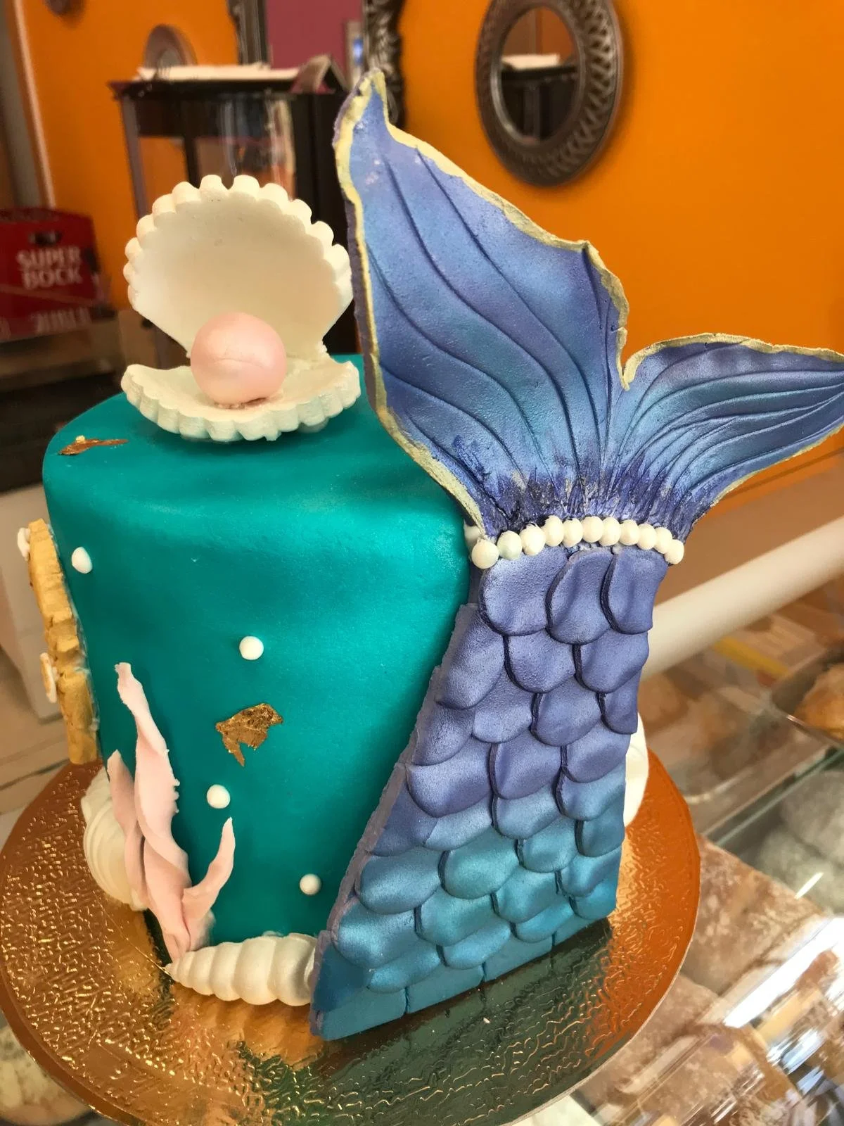 Teal mermaid tail cake with shells and scales