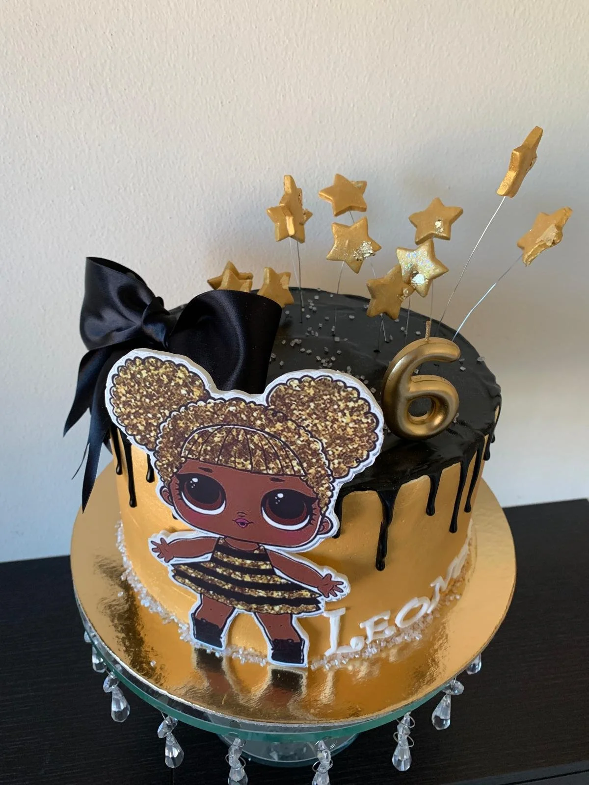 Doll-themed pink and gold birthday cake with a number 6
