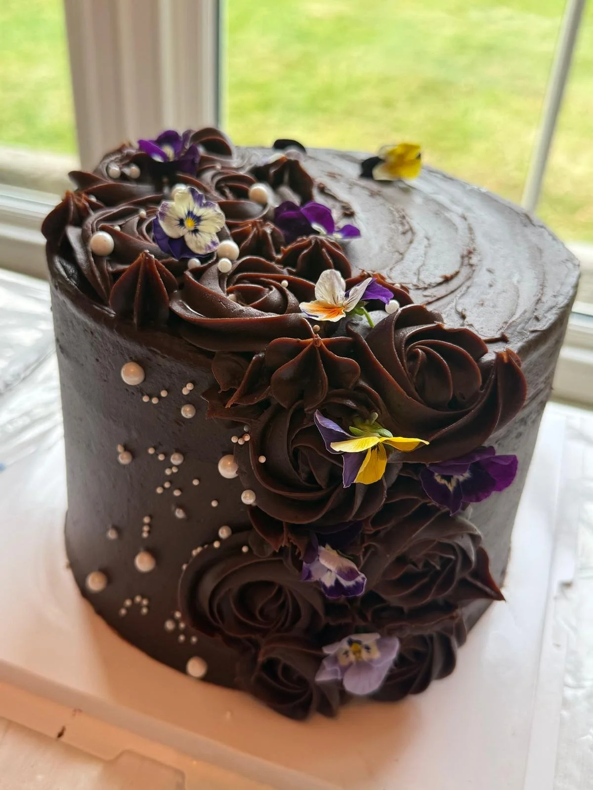 Chocolate buttercream cake topped with edible flowers