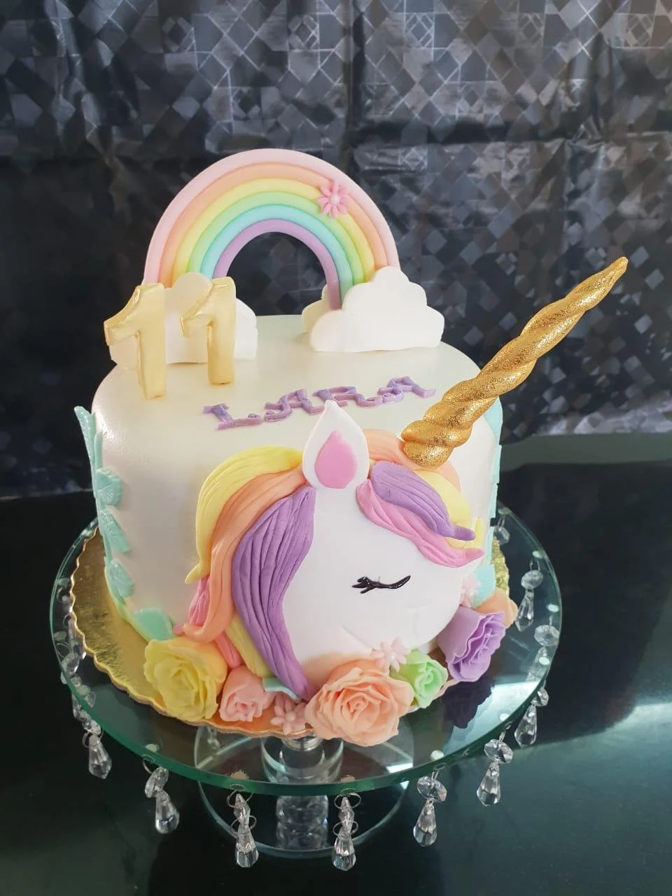 Pastel unicorn birthday cake with rainbow and gold horn