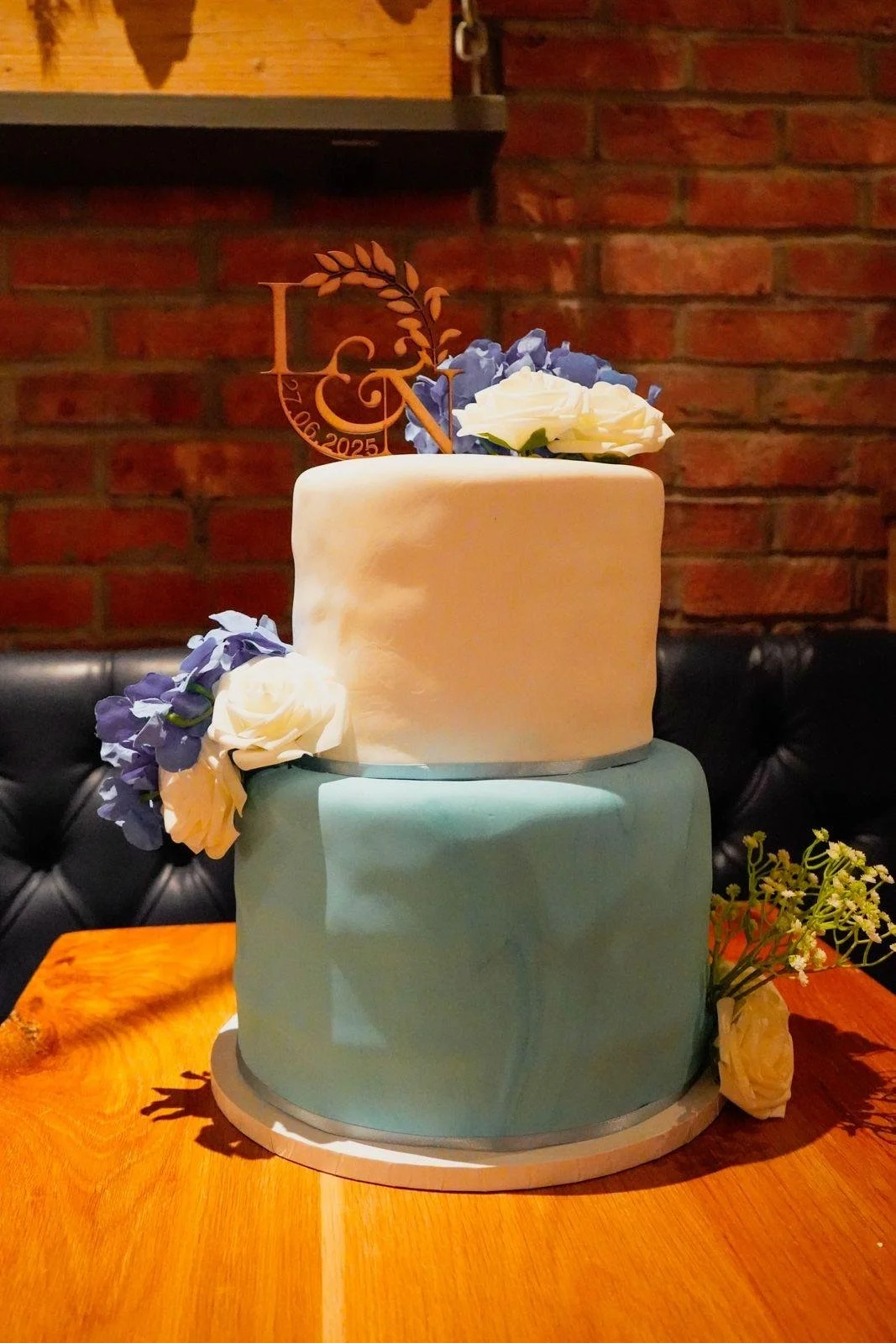 Blue and white two-tier celebration cake with white flowers