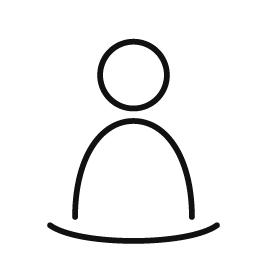 Person ved et bord – symbol på individuel sparring, refleksion og nye perspektiver.