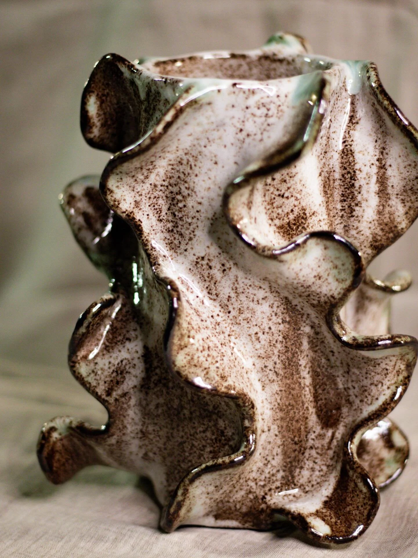 Wiggle vase made of black clay with a white glaze and splashes of copper oxide. 

📸: @the.madbitch 

#pottery #ceramics #handmade #craft #vase