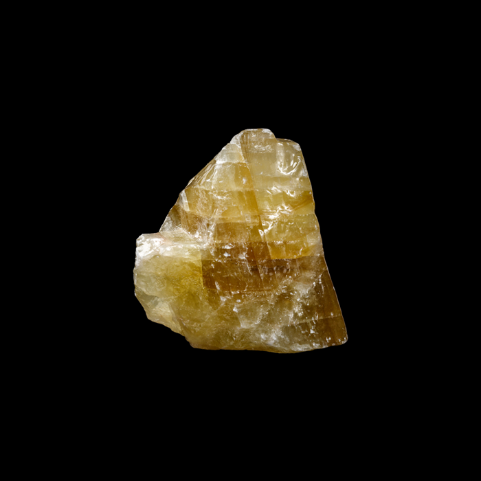 A large, light brown and translucent crystal or mineral specimen against a black background.