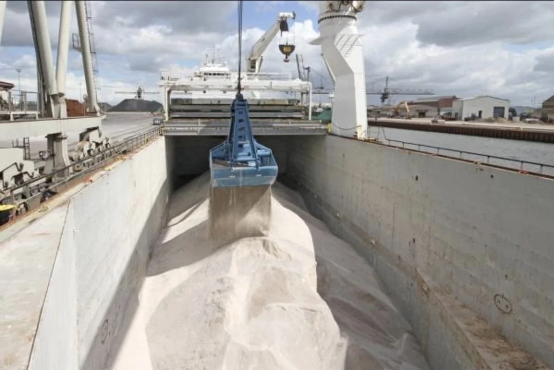 Un bateau de transport déposant du ciment dans une cargaison