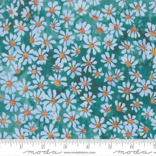 Fabric with a pattern of white daisies with yellow centers on a green background, with a measuring ruler at the bottom.