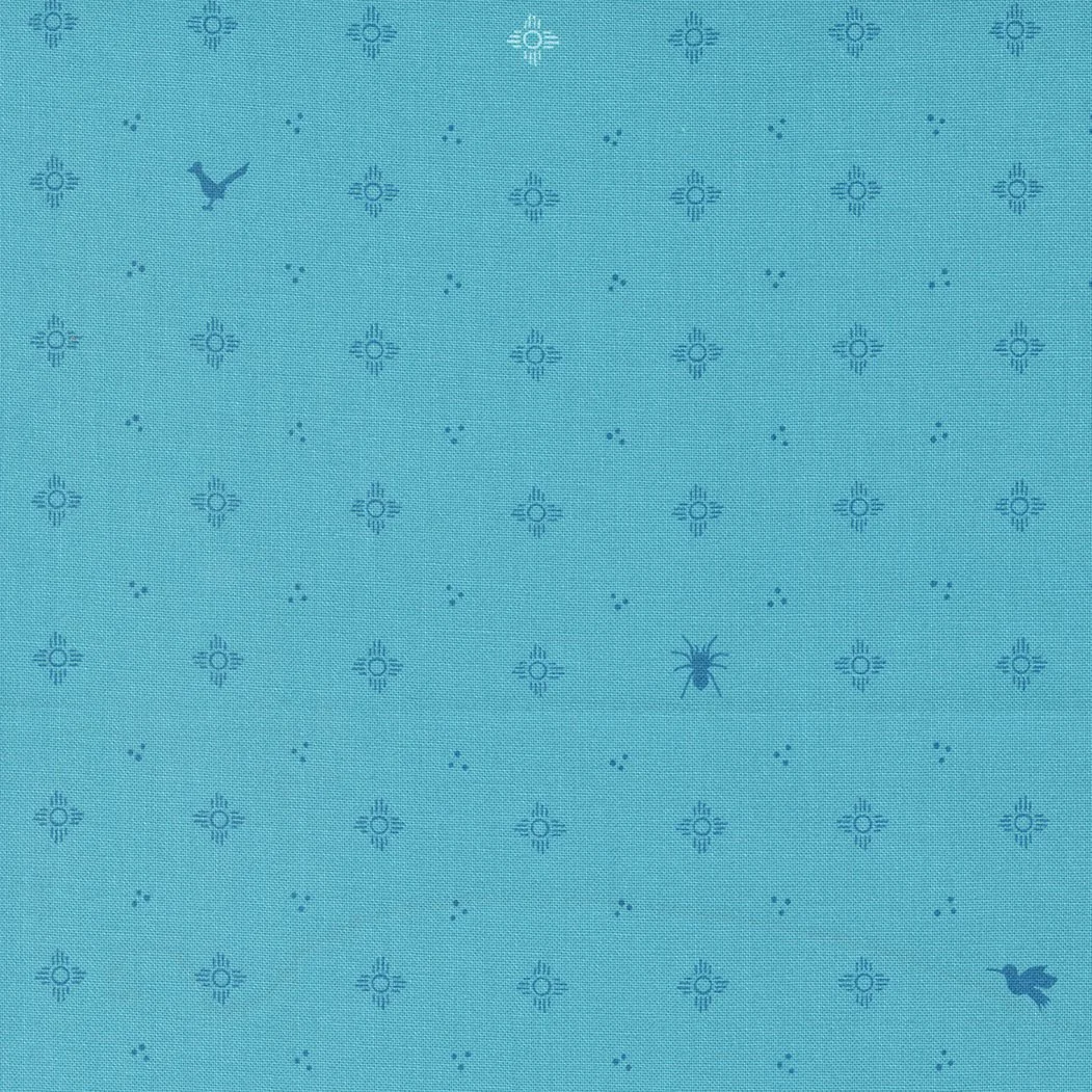Blue fabric with small sun designs and two hidden animals, a whale in the top left and a rabbit near the bottom right.