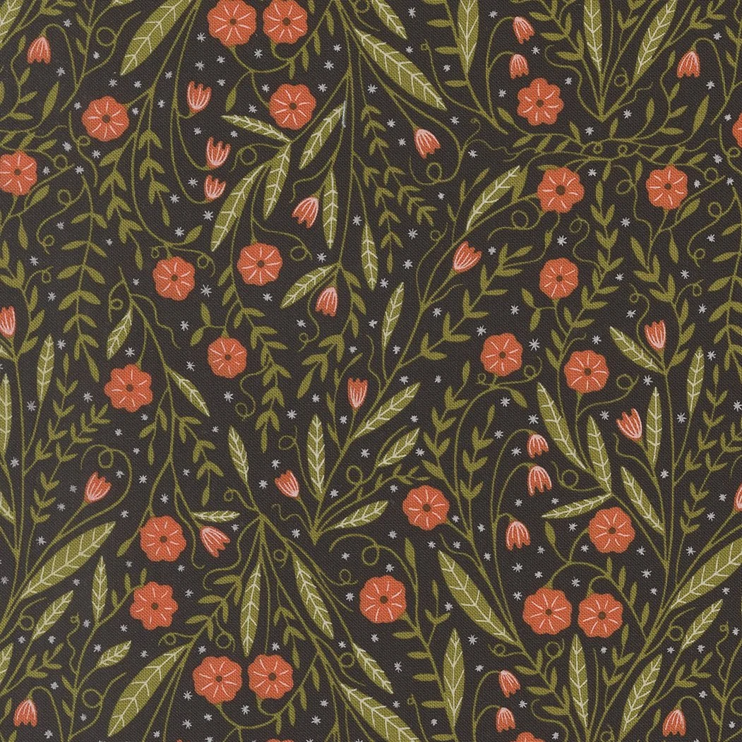 A fabric with a floral pattern featuring small red-orange flowers, green leaves, and white star-like accents on a black background.