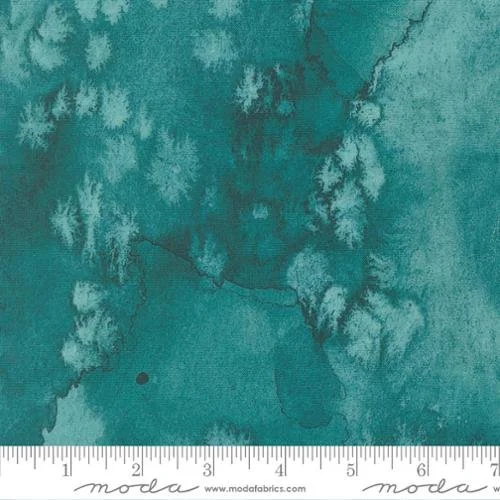 A close-up of a teal-colored fabric with a textured, tie-dye pattern.