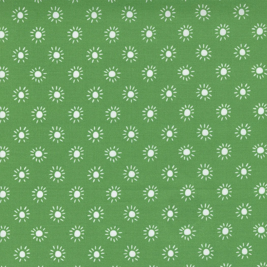 Green fabric with a pattern of small white sunburst shapes arranged in rows.