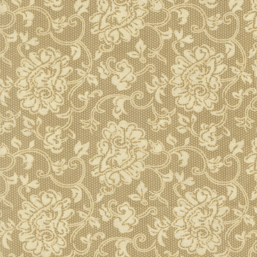 A close-up image of a beige and cream patterned fabric with floral and scroll motifs.