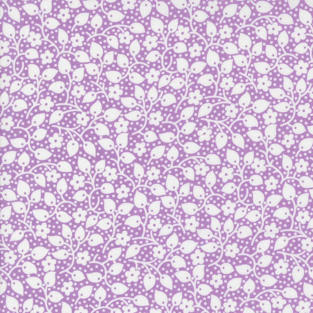 A purple fabric with a white floral pattern consisting of small flowers, leaves, and dotted vines.