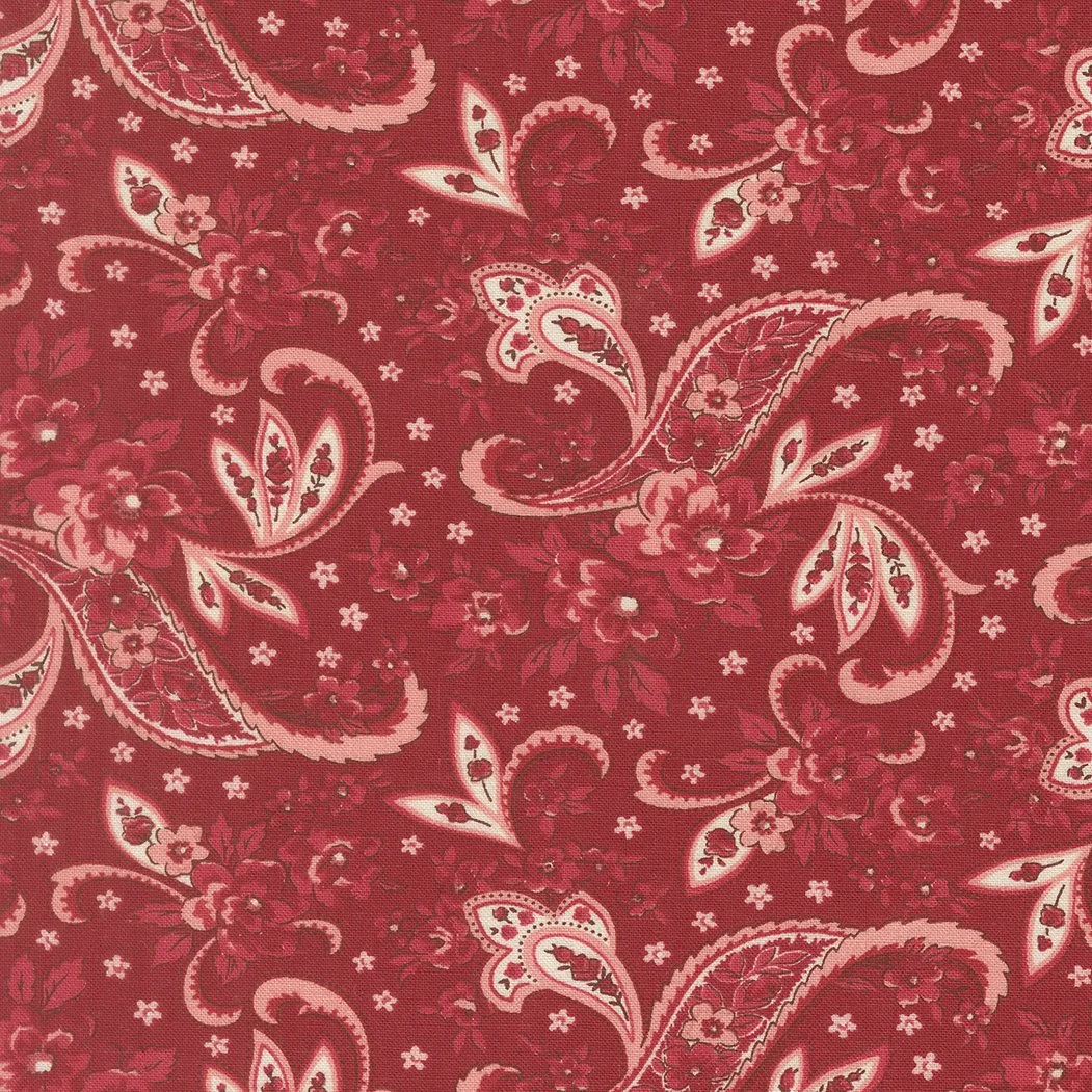Red fabric with a white and pink paisley floral pattern.