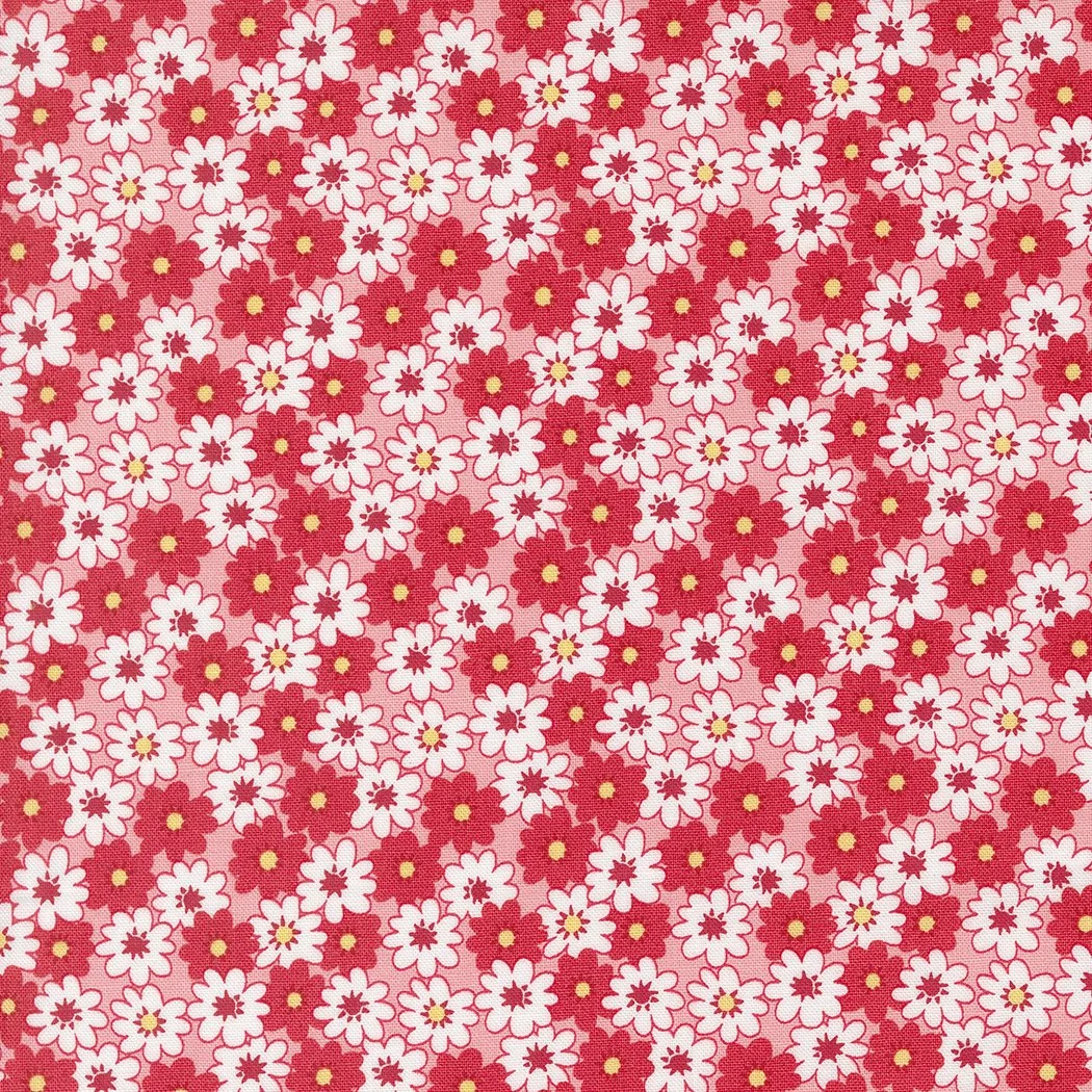 A pattern of small white and red flowers on a pink background.