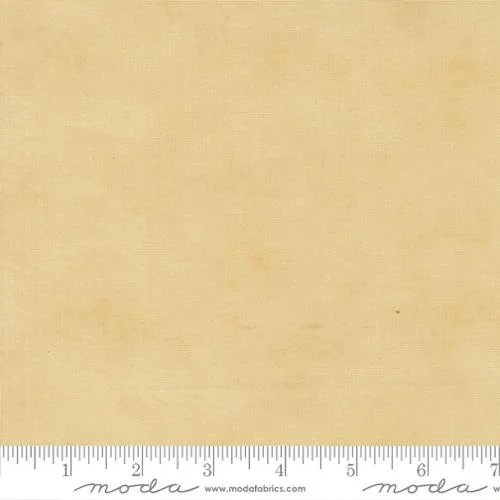 A sheet of beige fabric with a measuring ruler at the bottom, labeled 'Moda' and 'moda fabrics'.