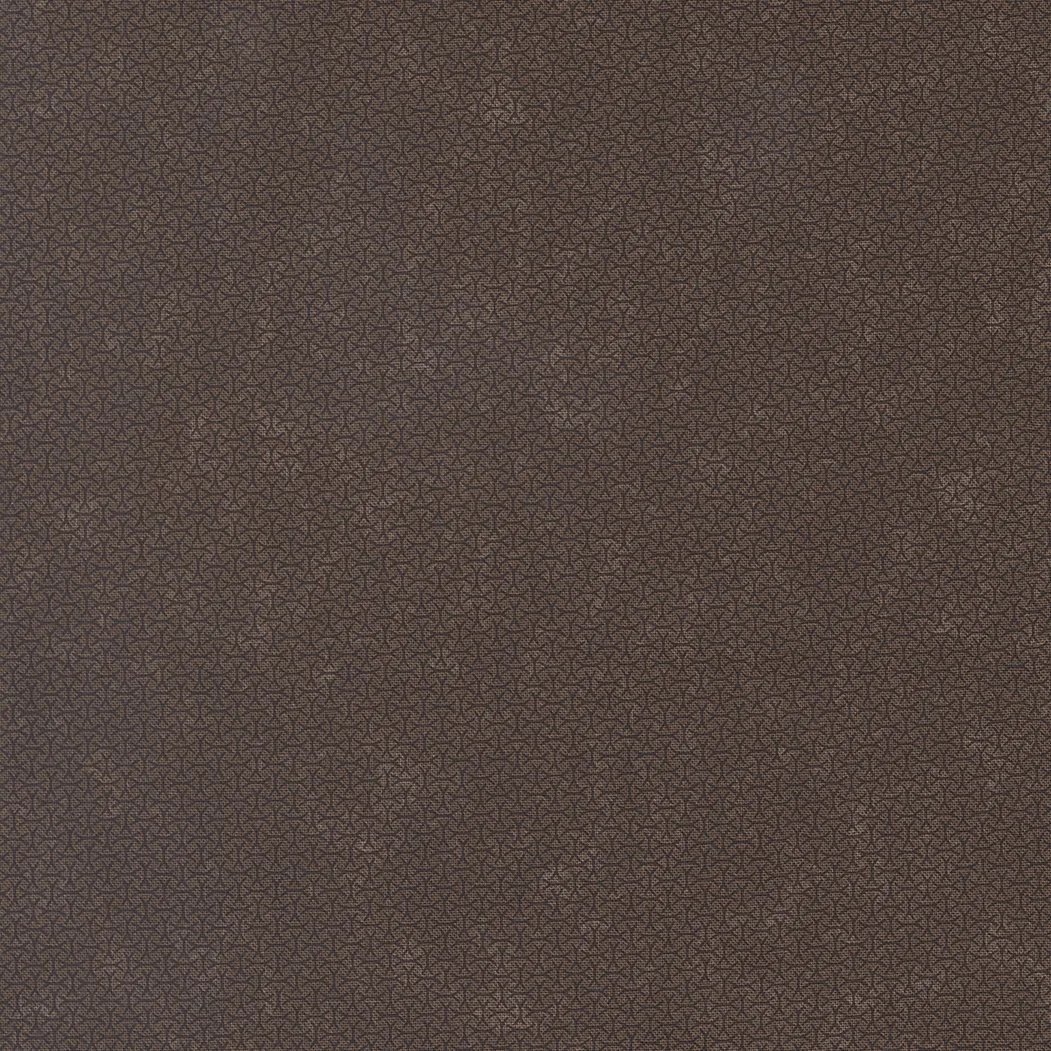 Close-up of brown, textured fabric with small intricate pattern.