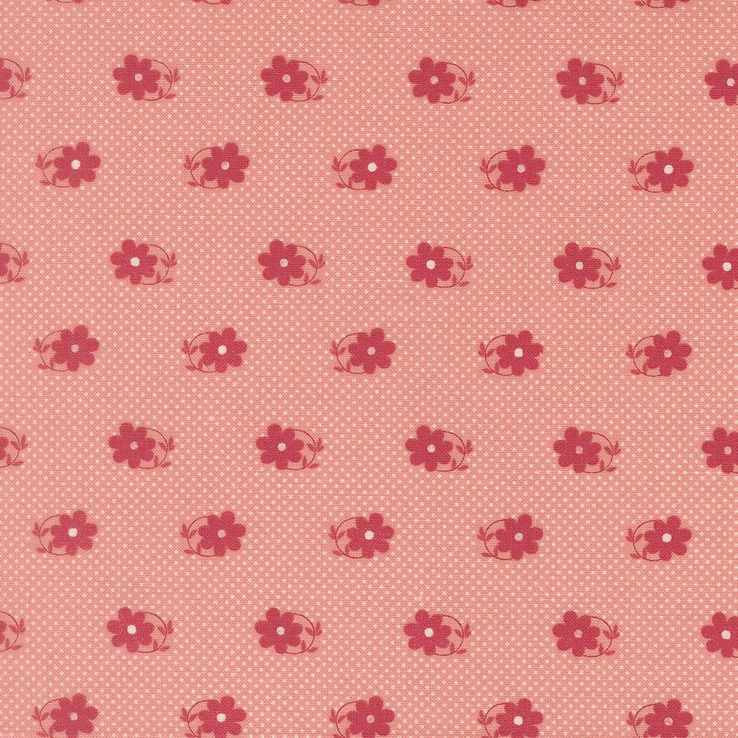 Pink fabric with a pattern of red flowers and small white polka dots.