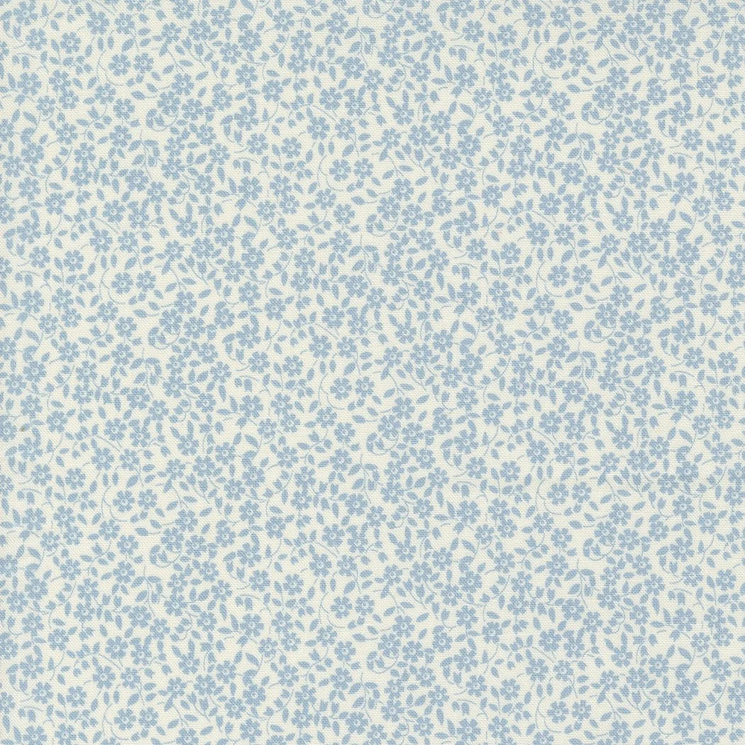 A fabric with a tiny floral pattern in light blue on a cream background.