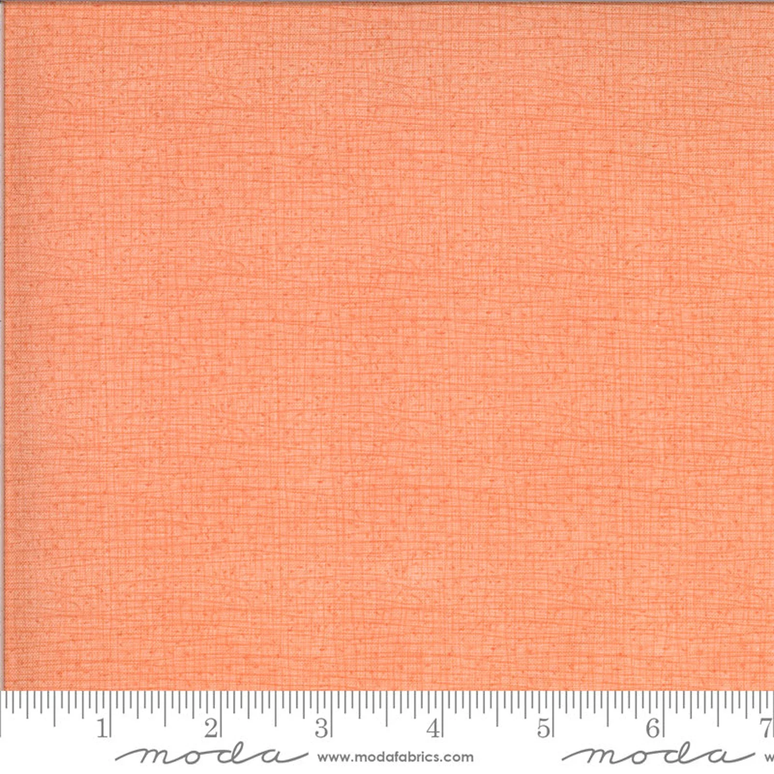 Close-up of a piece of textured, peach-colored fabric with a ruler at the bottom measuring about 7 inches.