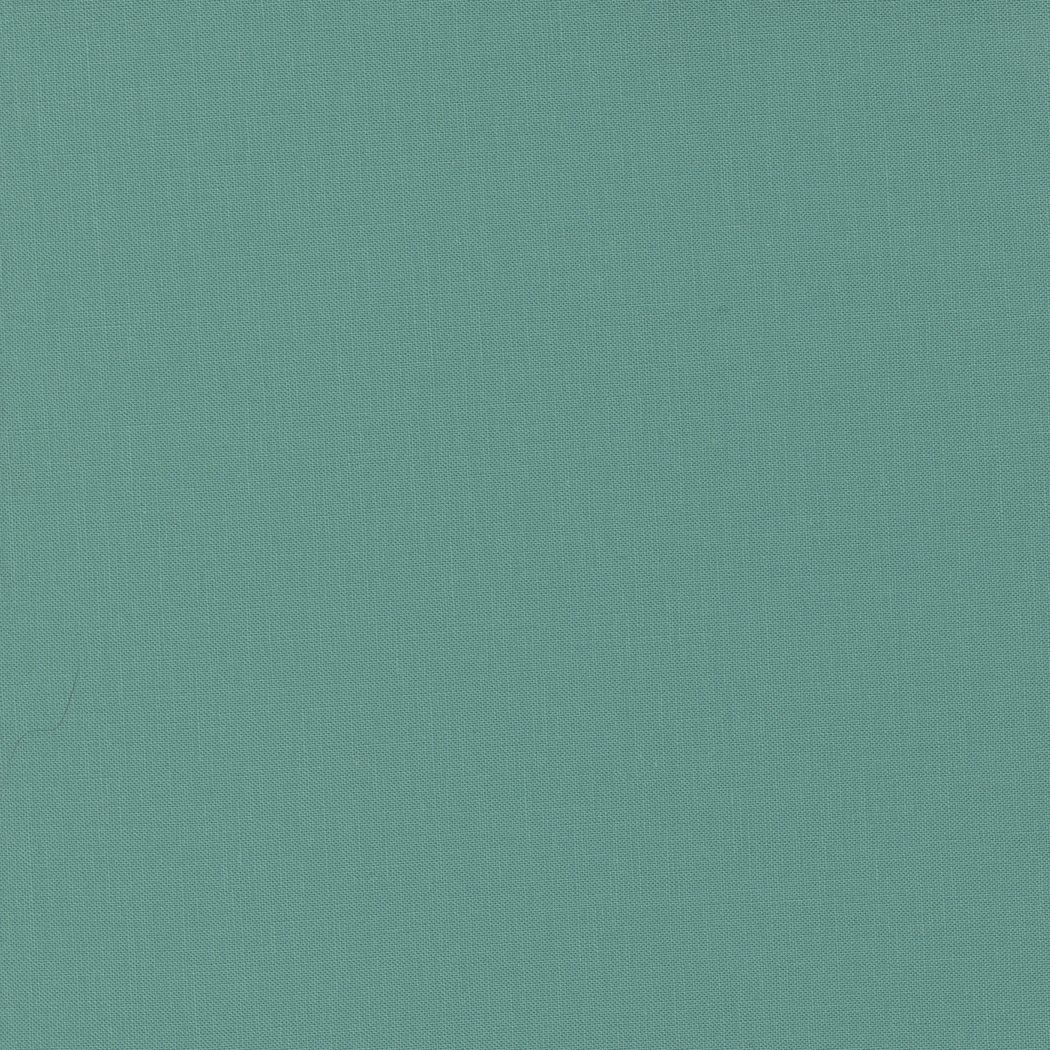 Close-up of a teal-colored, textured fabric surface.