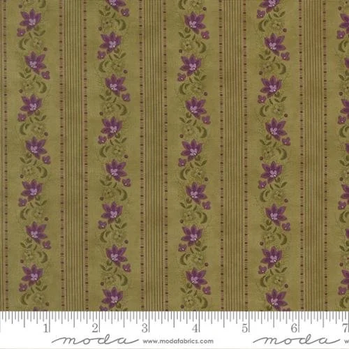 Close-up image of fabric with vertical green and purple floral pattern, including a ruler at the bottom indicating measurement.