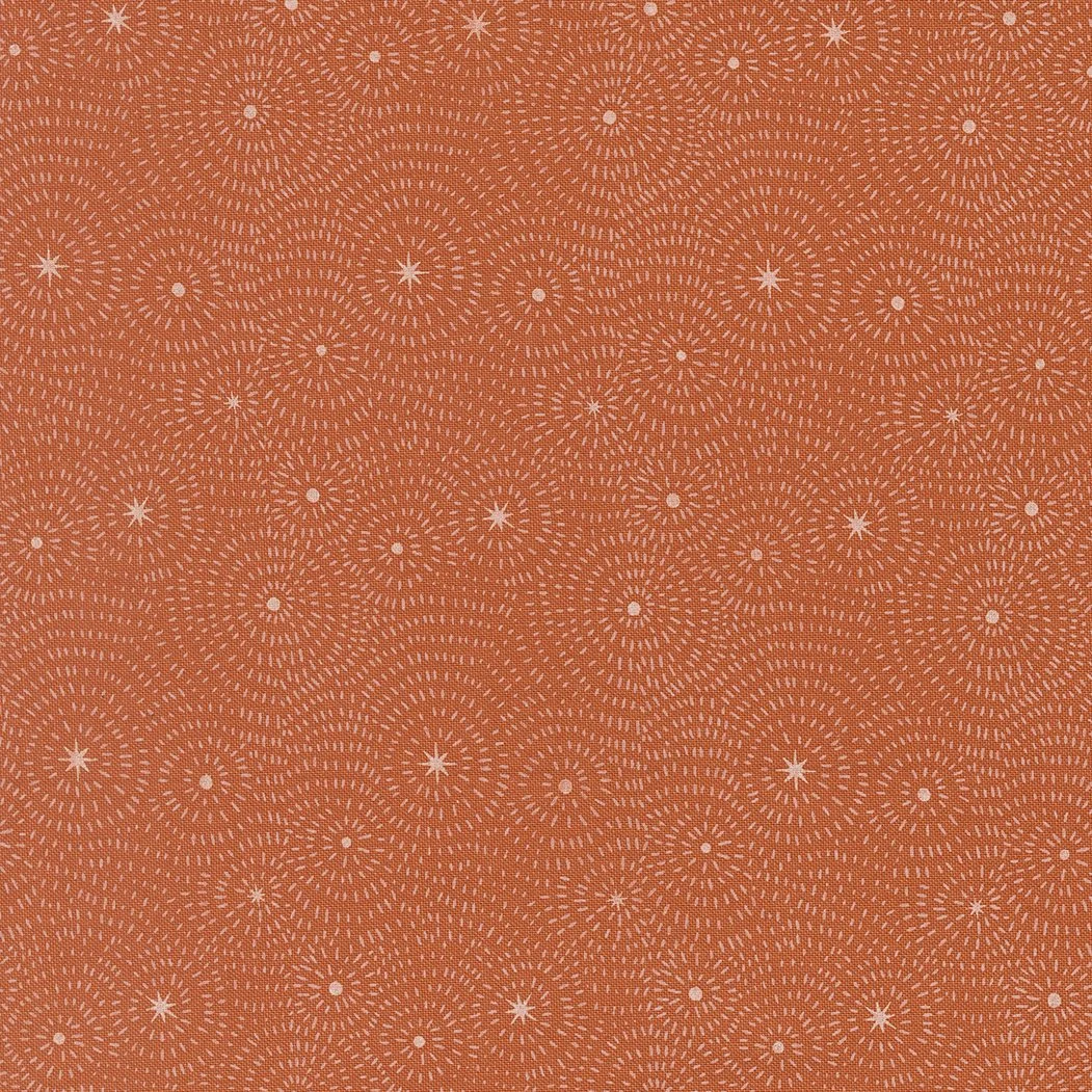 Orange fabric with a repeating white starburst and dotted pattern.