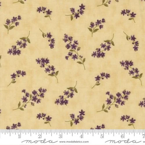 Fabric with a pattern of purple lavender flower clusters and green leaves on a yellowish background.