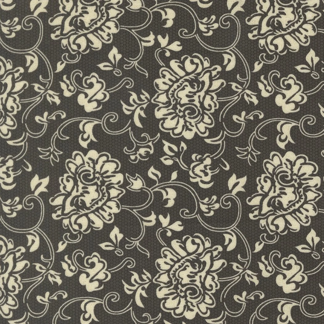 Black fabric with an intricate cream-colored floral and vine pattern.