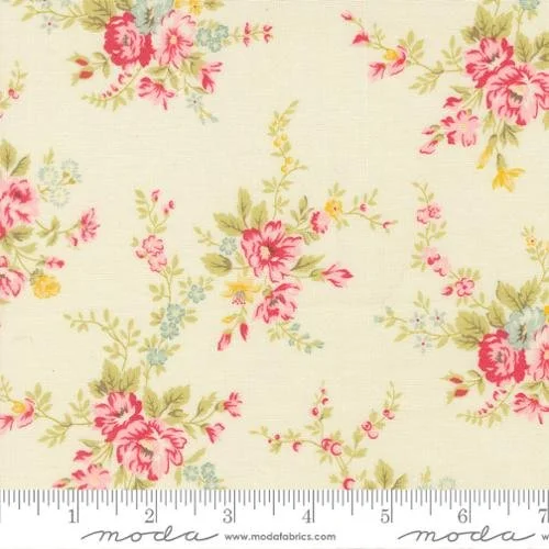 Fabric with a cream background featuring pink, green, yellow, and blue floral pattern and a ruler at the bottom.