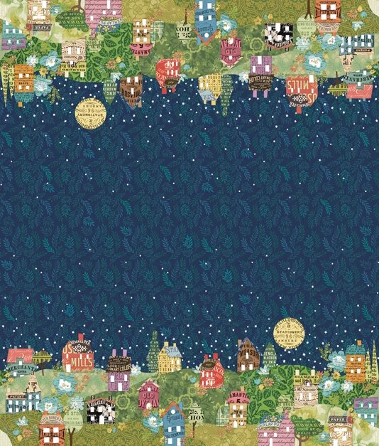 A festive holiday fabric with a border of colorful houses, trees, and snowflakes surrounding a blue night sky filled with snow, a bright full moon, and a dark silhouette of pine trees.