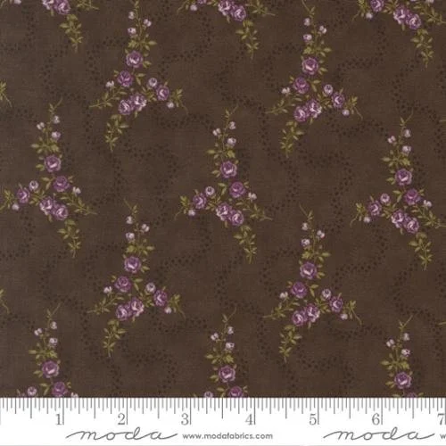 Brown fabric with purple floral pattern and small dotted details, with a white measuring tape at the bottom.