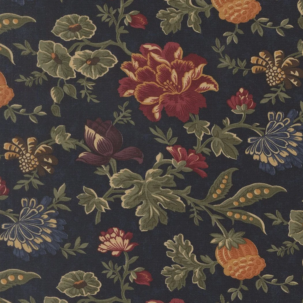 Close-up of floral patterned fabric with large red, orange, yellow, and blue flowers, green leaves, and smaller floral accents on a dark background.