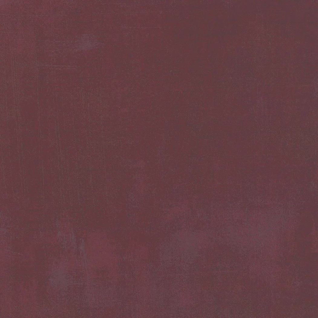 A textured surface with a mix of maroon and purple hues.