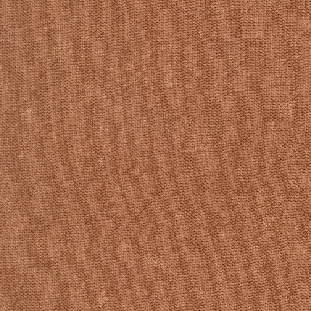 Close-up of a textured, rust-colored fabric with a subtle diamond pattern.