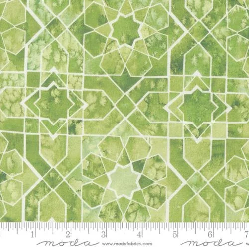 A fabric pattern featuring a green tile design with white outlines and geometric shapes, including stars and squares.