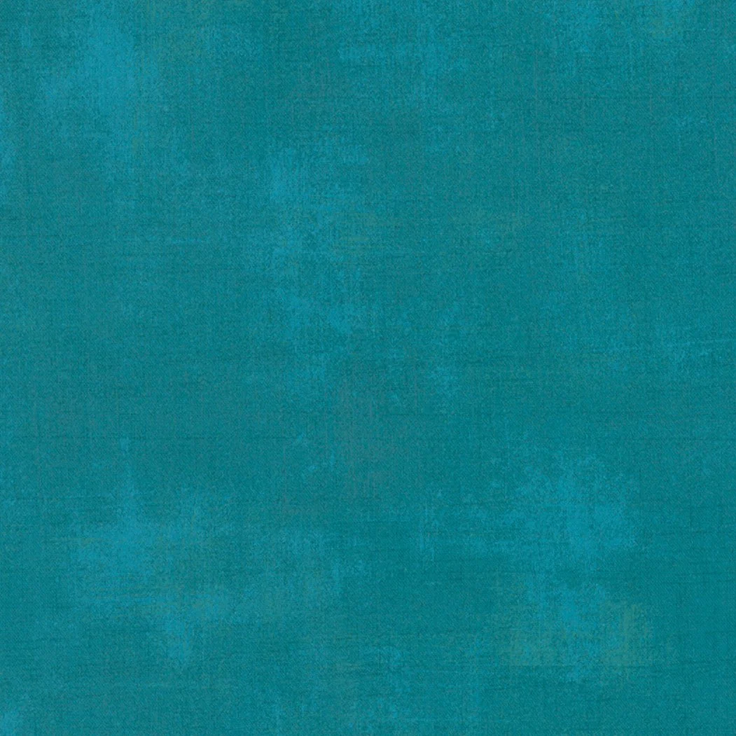 A textured, solid teal-colored surface.