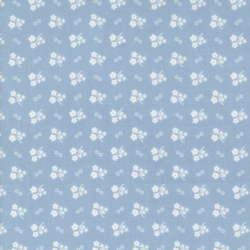 A light blue fabric with white floral patterns and small circles.