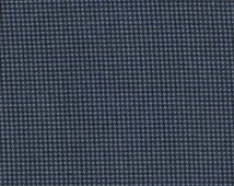 Close-up of a textured dark blue fabric with small, closely spaced white dots.