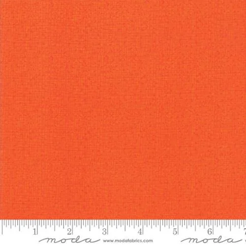 Close-up of orange fabric with measurement markings at the bottom.