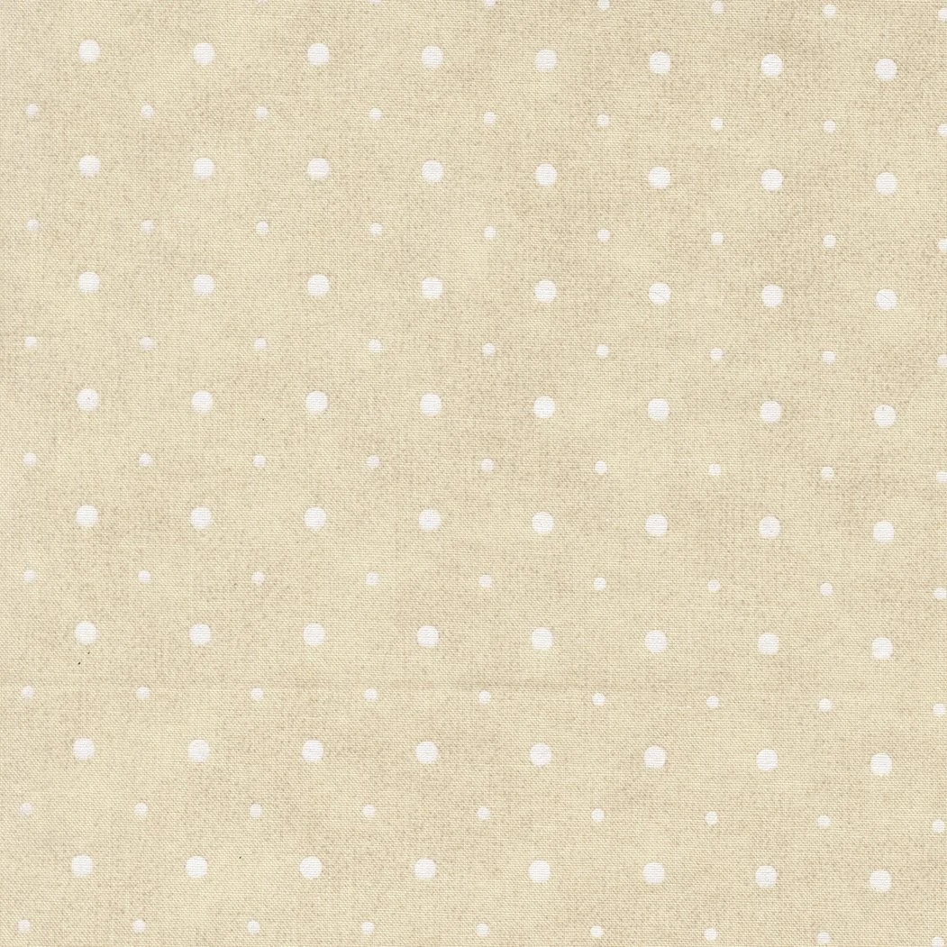 Close-up of beige fabric with white polka dots.
