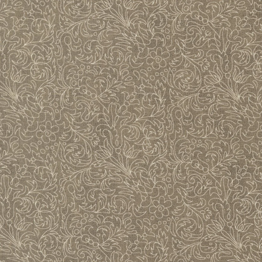 A beige fabric or wallpaper with a white floral vine pattern.