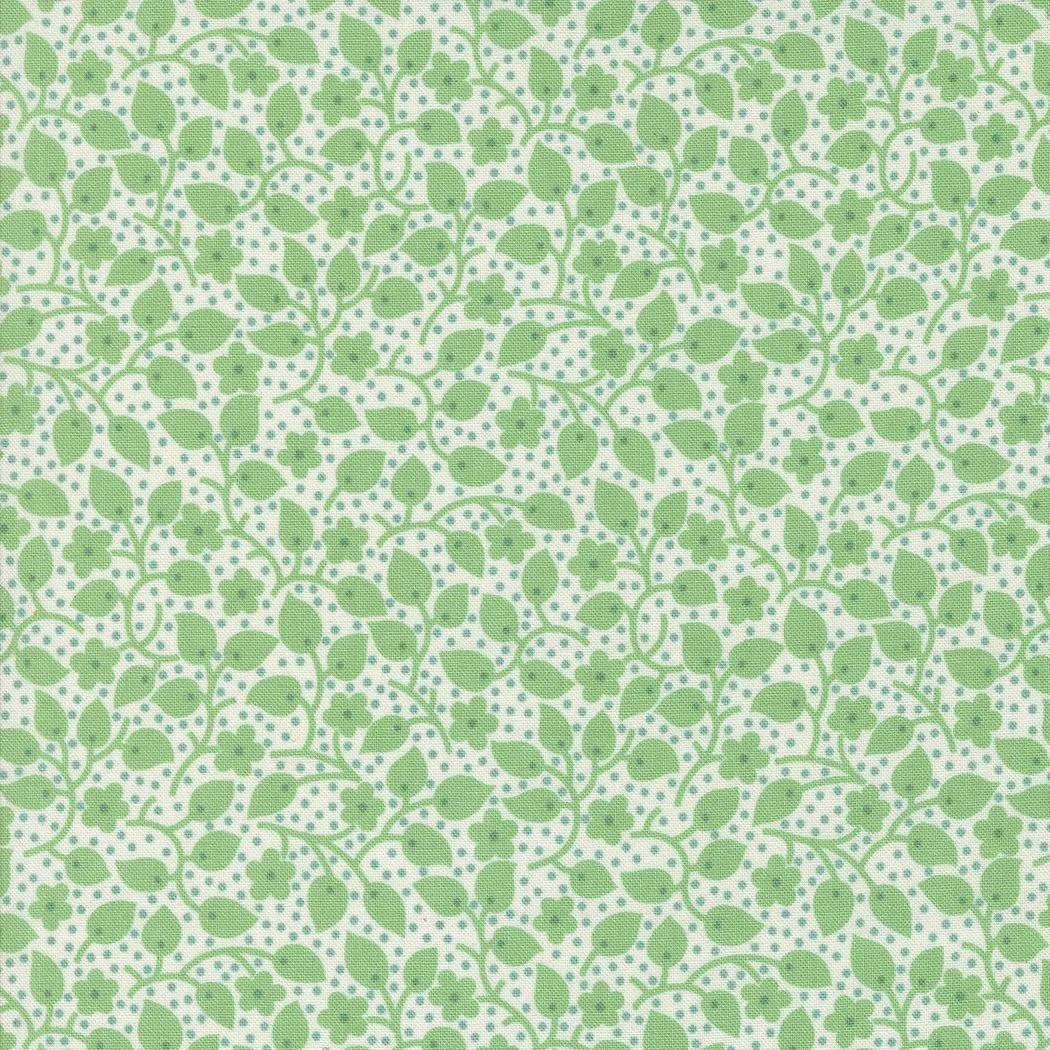 Close-up of a green and white floral fabric pattern with small leaves and flowers.