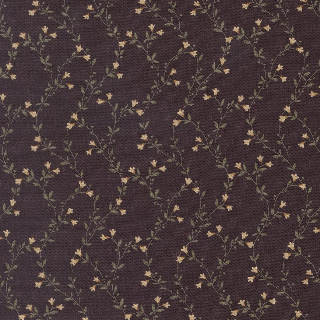 Patterned fabric with a dark maroon background and small, delicate floral vines with yellow flowers and green leaves.