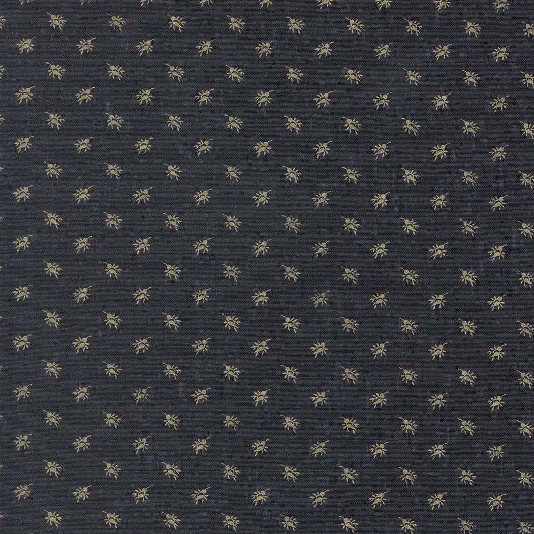 Close-up of a dark fabric with a repeating pattern of small, yellowish-golden spiders.