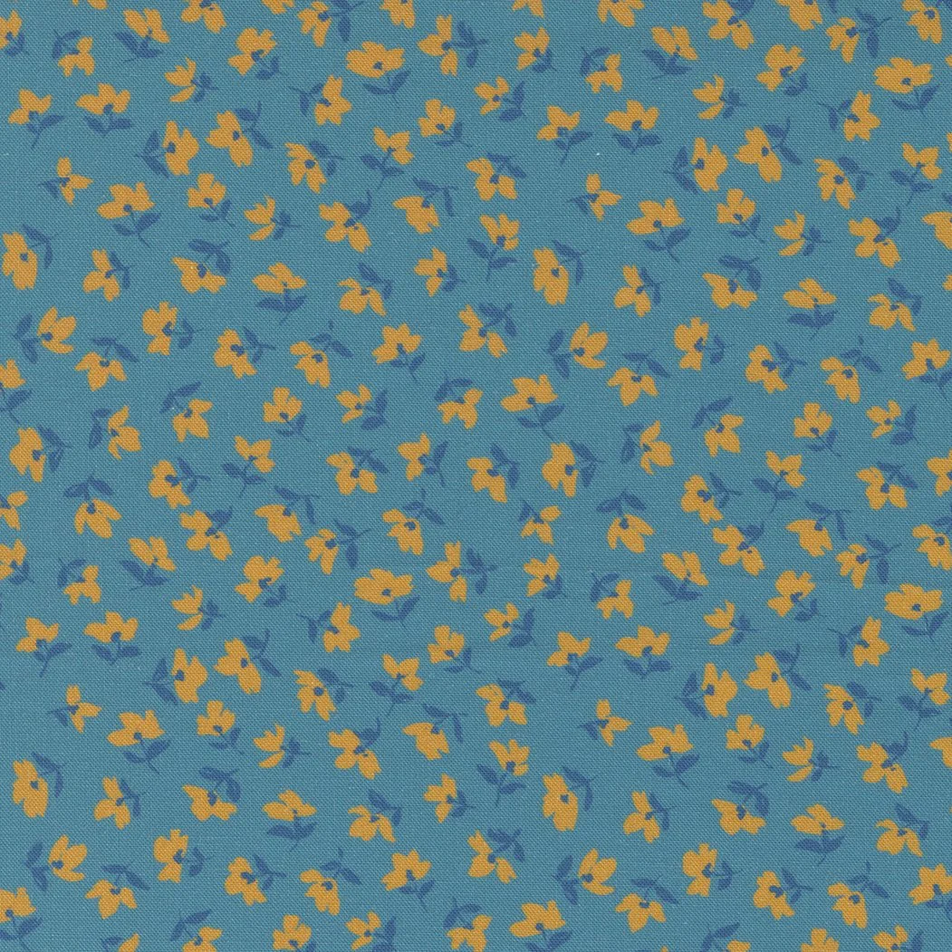 Close-up of a blue fabric with a yellow floral pattern.