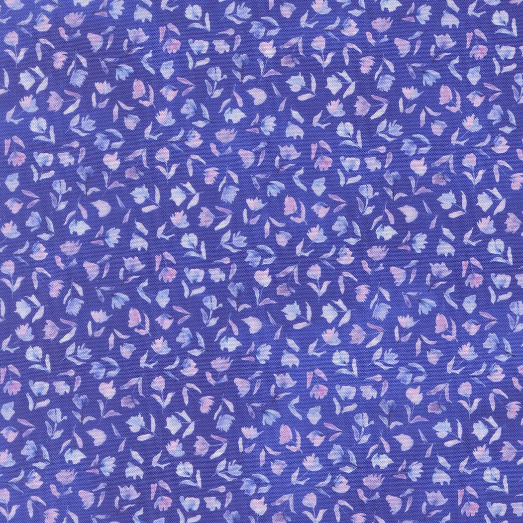 Close-up of fabric with a purple background and small, scattered floral and leaf patterns in pink and light blue colors.