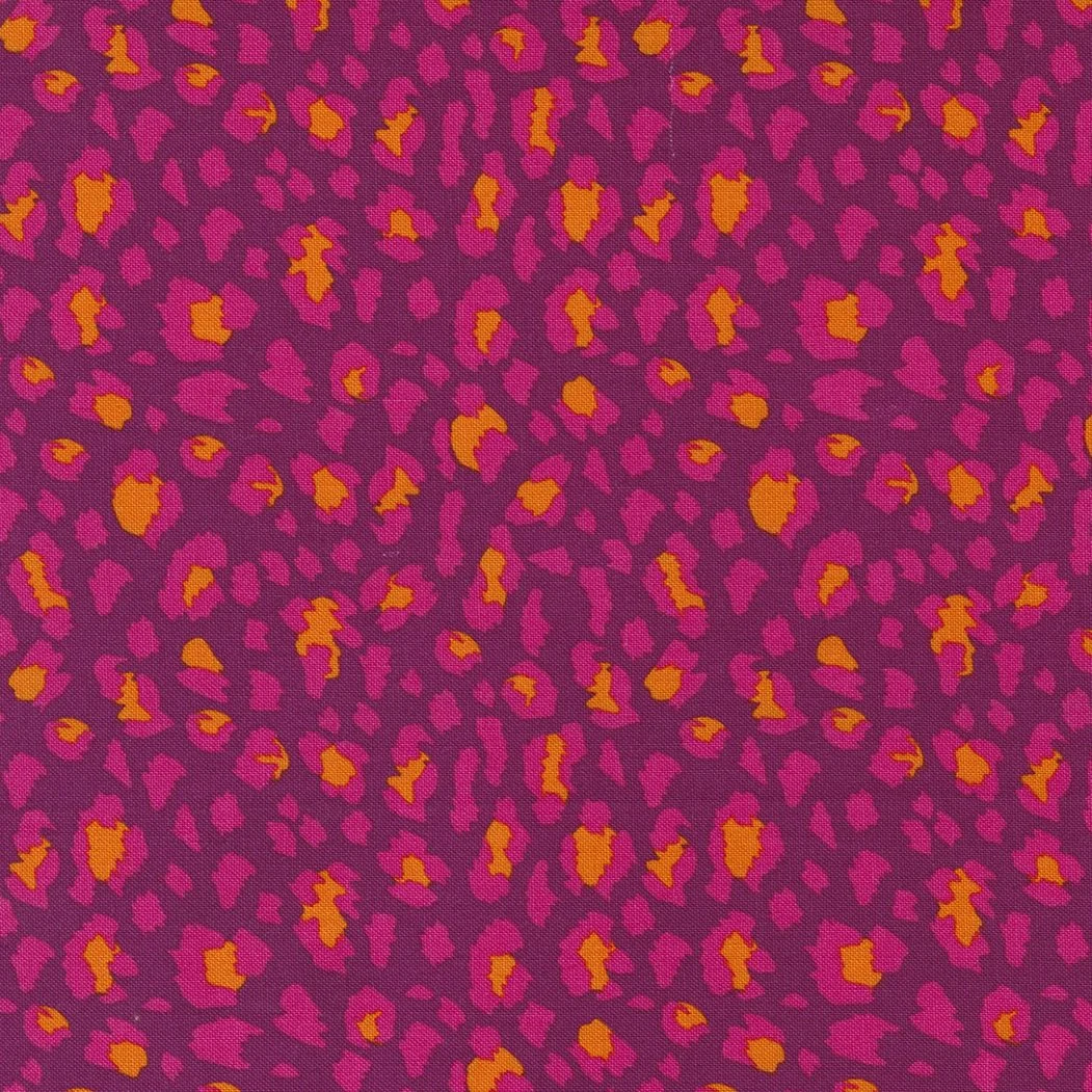 Close-up of a fabric with a pink and purple leopard print pattern with orange accents.