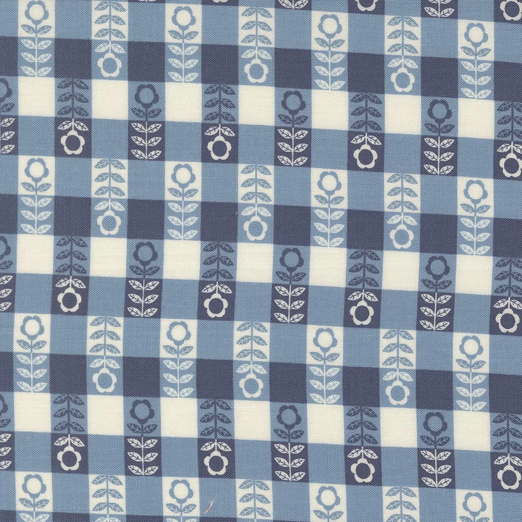 Close-up of a fabric with a checkered pattern in shades of blue and white, featuring floral motifs.