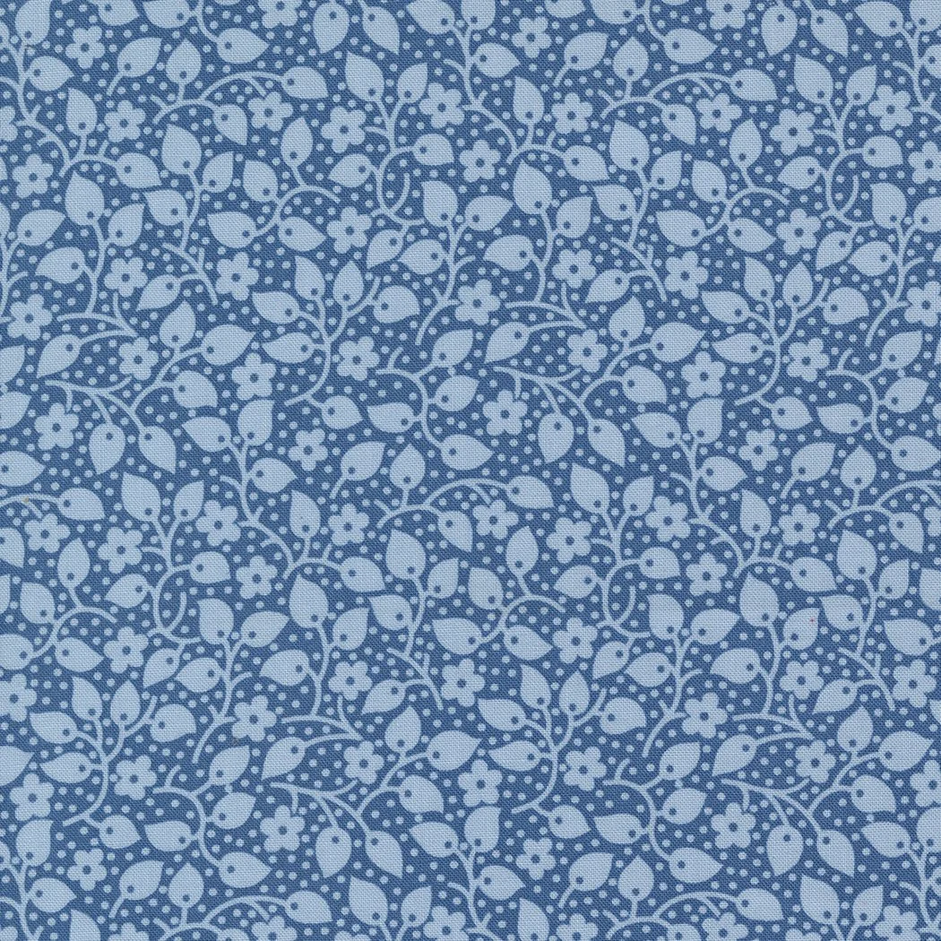 Blue fabric with a white floral and leaf pattern and dotted details.