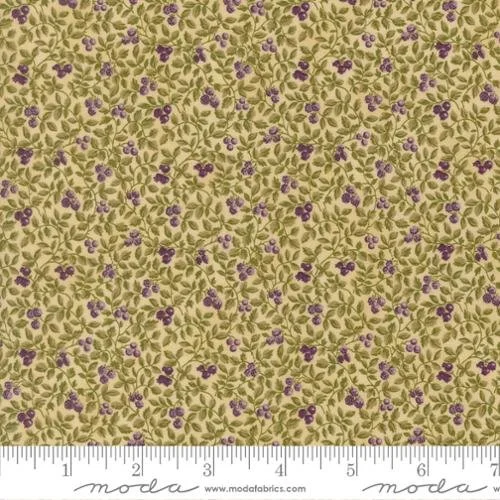 Close-up of fabric with yellow background, green leaves, and small purple flowers, with a ruler at the bottom for scale.